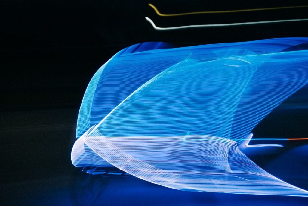 Blue light streaks forming a smooth abstract wave on black