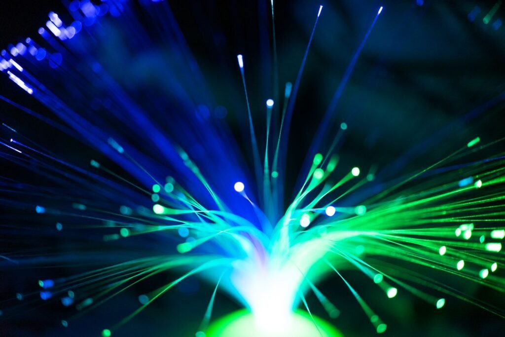 Illuminated blue and green fiber optic strands radiating outward